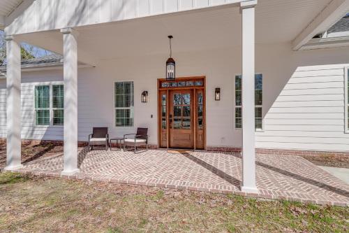 a front porch of a white house with a wooden door at The Hamilton Heber Springs Home with Hot Tub! in Heber Springs