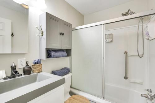 baño blanco con ducha y lavamanos en Single-Story Gillette Home Walk to Lake and Trails! en Gillette
