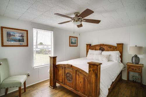 - une chambre avec un lit en bois et un ventilateur de plafond dans l'établissement Charming Home with Dock, Near Downtown Lake Charles!, à Lake Charles