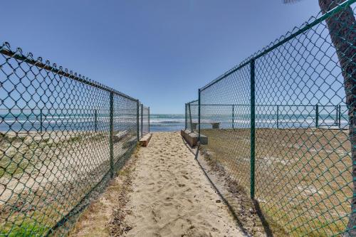 a fence on a beach with the ocean behind it at Ewa Beach Apartment with Beach Gear about 1 Mi to Ocean! in Kapolei
