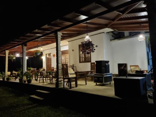 a patio with chairs and a table and a tv at JAYANDRA HOLIDAY BUNGALOW in Waga