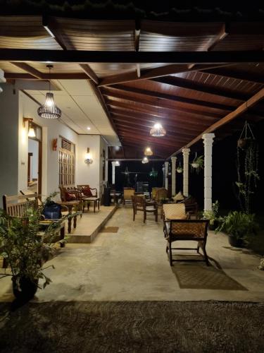 a living room with a bunch of chairs and tables at JAYANDRA HOLIDAY BUNGALOW in Waga