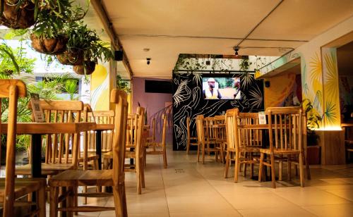 a restaurant with wooden tables and chairs and a television at Green Hotel Medellin in Medellín