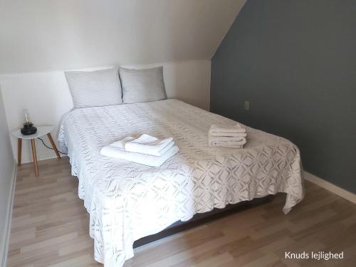 um quarto com uma cama com toalhas em Døssinghus Holiday Apartments em Kjellerup