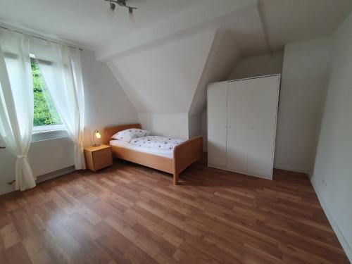 a small bedroom with a bed and a large window at Privatzimmer direkt an der Uniklinik Mainz in Mainz