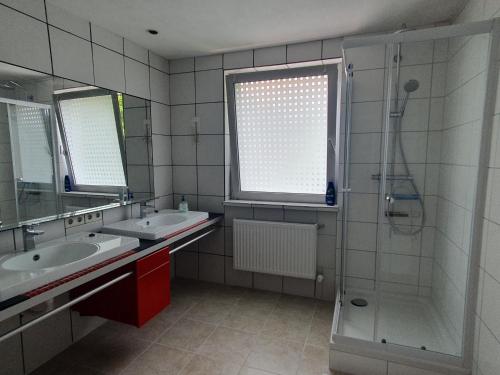 a bathroom with two sinks and a shower at Privatzimmer direkt an der Uniklinik Mainz in Mainz
