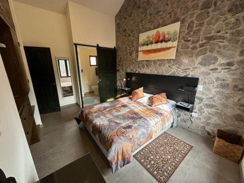 een slaapkamer met een bed en een stenen muur bij Loft Edoardo en Val'Quirico in Santeagueda