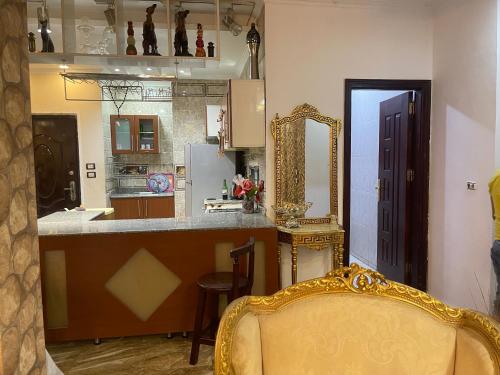 ‘Ezbet el-Insha的住宿－شقه متميزه بالحي التاسع，厨房配有柜台、镜子和椅子