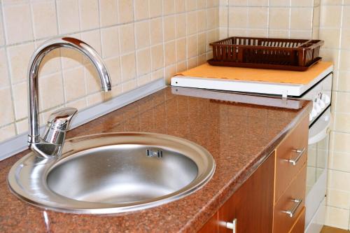 a kitchen counter with a sink and a basket on it at Guest House Sani in Skopje