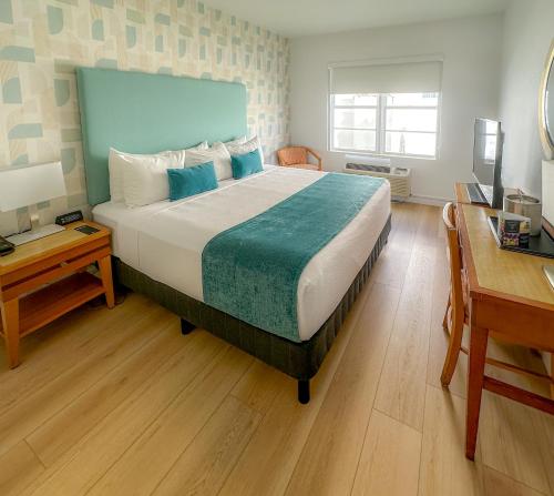a bedroom with a large bed with a desk and a desk at Avalon Hotel in Miami Beach