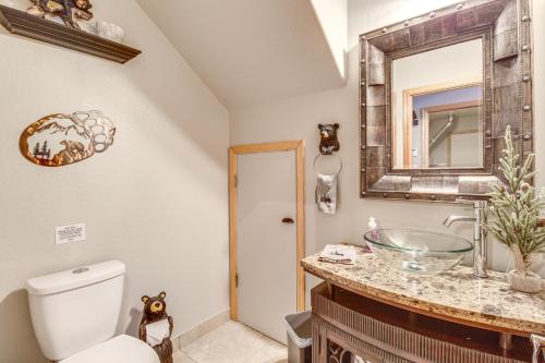 y baño con aseo, lavabo y espejo. en Spacious Pinetop Cabin with Private Yard and Hot Tub!, en Indian Pine