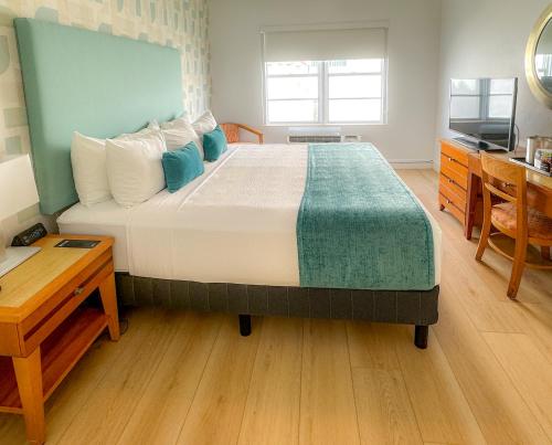 a bedroom with a bed and a desk and a television at Avalon Hotel in Miami Beach