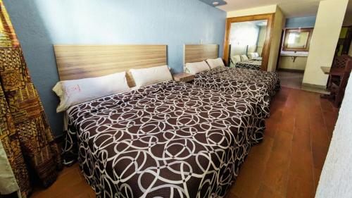a bedroom with a large bed in a room at Hotel Plaza San Juan in Mexico City