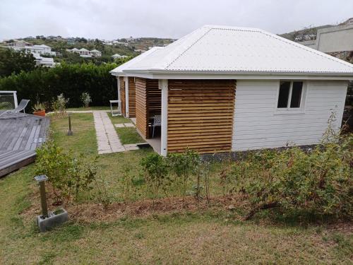 a small white house with a roof and a yard at B. O. PARADIS SXM in Orient Bay