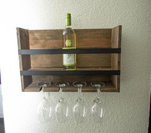 a bottle of wine hanging on a wall with wine glasses at Vintage Elegance - Condo Steps Away from Casino in Hot Springs