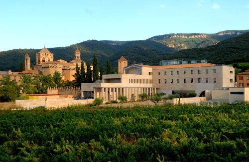 a group of buildings with mountains in the background at Hostatgeria de Poblet in Poblet