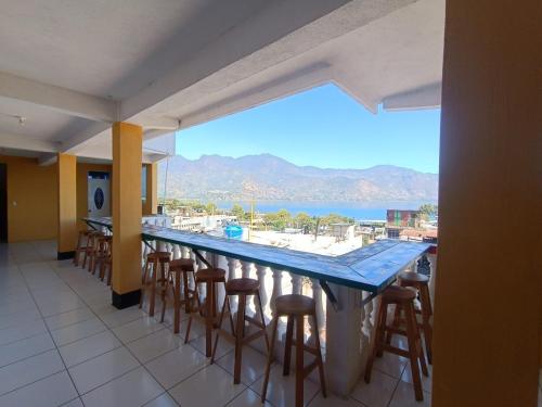 a bar with stools and a view of the ocean at CASA EMILY in San Pedro La Laguna