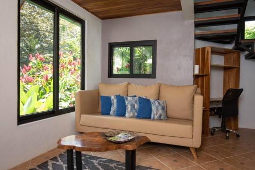 a living room with a couch and a table at Casa Pura Vida Manuel Antonio in Manuel Antonio