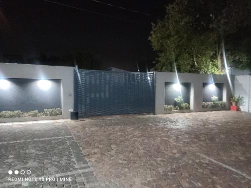 a courtyard at night with lights on a fence at The Croc Guest house in Springs