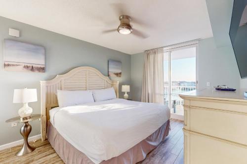 a bedroom with a bed and a large window at The Terrace at Pelican Beach 304 in Destin