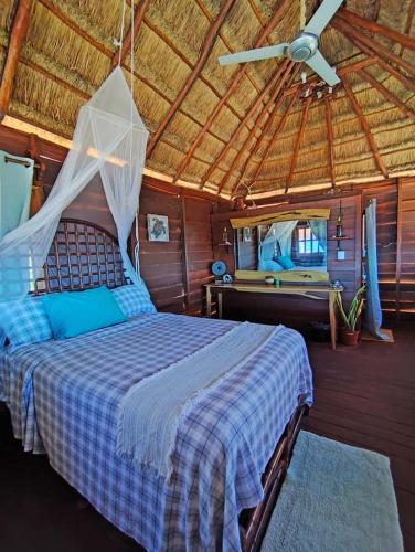 a bedroom with a bed with a mosquito net at Experiencia Casa Blanca in Dzilam de Bravo
