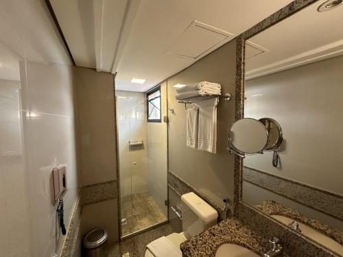 W łazience znajduje się umywalka, toaleta i lustro. w obiekcie Lets Idea Brasilia Hotel - Flat Particular w mieście Brasília