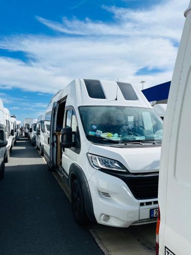 a row of white vans parked in a parking lot at Campervan for family in Charco del Pino