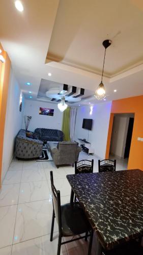 comedor y sala de estar con mesa y sillas en Residence GermanoTech, Bonamoussadi,Logbessou appartement meublé 2ch,1salon eau chaude,Wifi,parking,virgile,menagere,canalsat, en Douala