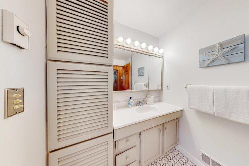 a bathroom with a sink and a mirror at Comfy Cabin by the Sea in Nehalem