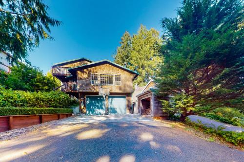 a house with a driveway in front of it at Comfy Cabin by the Sea in Nehalem