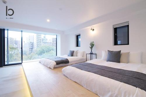 2 camas en un dormitorio con ventana grande en bHOTEL Heiwaoodori 401 - Brand New Apt Famous Hiroshima Dori 6ppl en Hiroshima