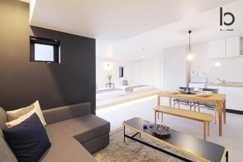 sala de estar con sofá y mesa en bHOTEL Heiwaoodori 401 - Brand New Apt Famous Hiroshima Dori 6ppl en Hiroshima