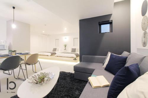a living room with a couch and a table at b hotel Heiwaodori 202 - New Apt Famous Hiroshima Hondori for 6p in Hiroshima