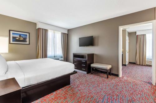 a hotel room with a bed and a television at Best Western Airport Inn & Suites in Charleston