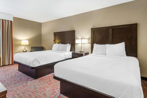 a hotel room with two beds and a chair at Best Western Airport Inn & Suites in Charleston