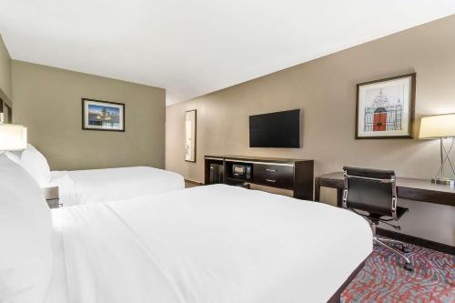 a hotel room with two beds and a flat screen tv at Best Western Airport Inn & Suites in Charleston