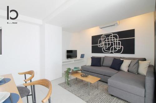 a living room with a couch and a table at b hotel Heiwaodori 701 - Spacious Apt Famous Hiroshima Dori 6ppl in Hiroshima