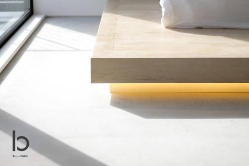 a close up of a bed with a wooden table at b hotel Heiwaodori 601 - New Apt In Famous Hiroshima Dori For 6p in Hiroshima