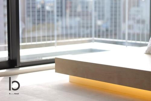 a bed in a room with a large window at b hotel Heiwaodori 701 - Spacious Apt Famous Hiroshima Dori 6ppl in Hiroshima
