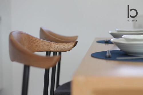 a table with two chairs and bowls on top of it at b hotel Heiwaodori 701 - Spacious Apt Famous Hiroshima Dori 6ppl in Hiroshima