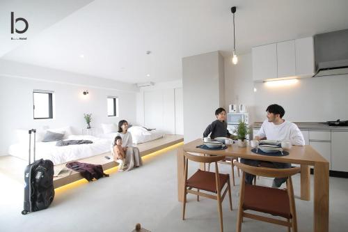 a group of people sitting at a table in a bedroom at b hotel Heiwaodori 1001 - Brand new Apt Famous Hiroshima dori 6p in Hiroshima