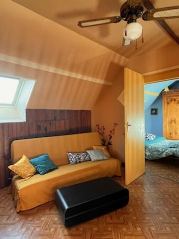 un salon avec un canapé et un lit dans l'établissement Maison de famille, à Pré-en-Pail