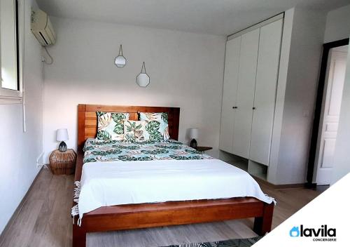 - une chambre avec un grand lit et une tête de lit en bois dans l'établissement Les Hauts de Devarieux - Sérénité & Horizon, à Garnier
