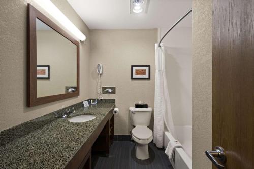 a bathroom with a toilet and a sink and a mirror at Comfort Inn Huntington Near University in Huntington