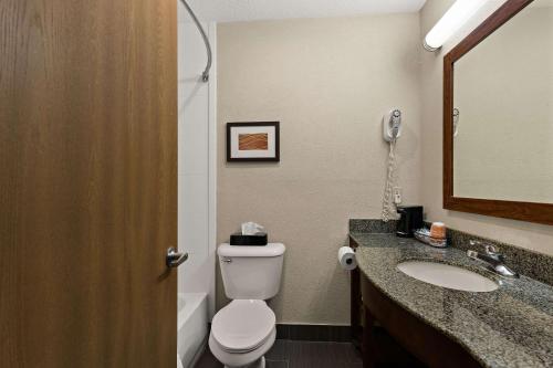 a bathroom with a toilet and a sink and a mirror at Comfort Inn Huntington Near University in Huntington