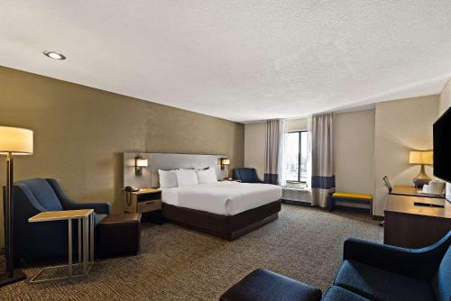 um quarto de hotel com uma cama e cadeiras em Comfort Inn Huntington Near University em Huntington