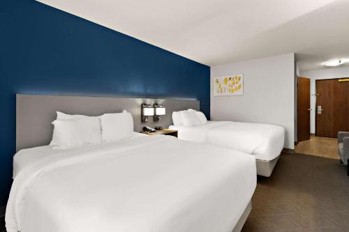 a hotel room with two beds and a blue wall at Comfort Inn & Suites in Fremont
