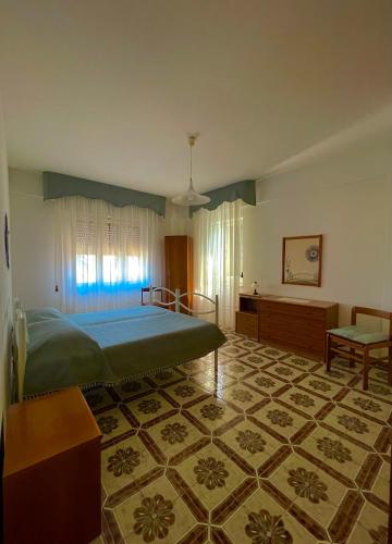 una camera con un grande letto e un tavolo di Pinníga’s House Mega appartamento vista mare a Santa Maria Navarrese
