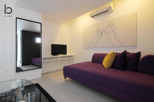a living room with a purple couch and a mirror at bHOTEL Heiwaoodori - New Apt in Famous Hiroshima Dori Max 6p in Hiroshima