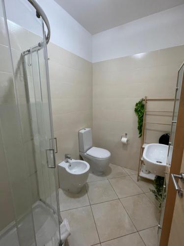 a bathroom with a toilet and a sink and a shower at Camere Aeroporto Cagliari Elmas in Elmas